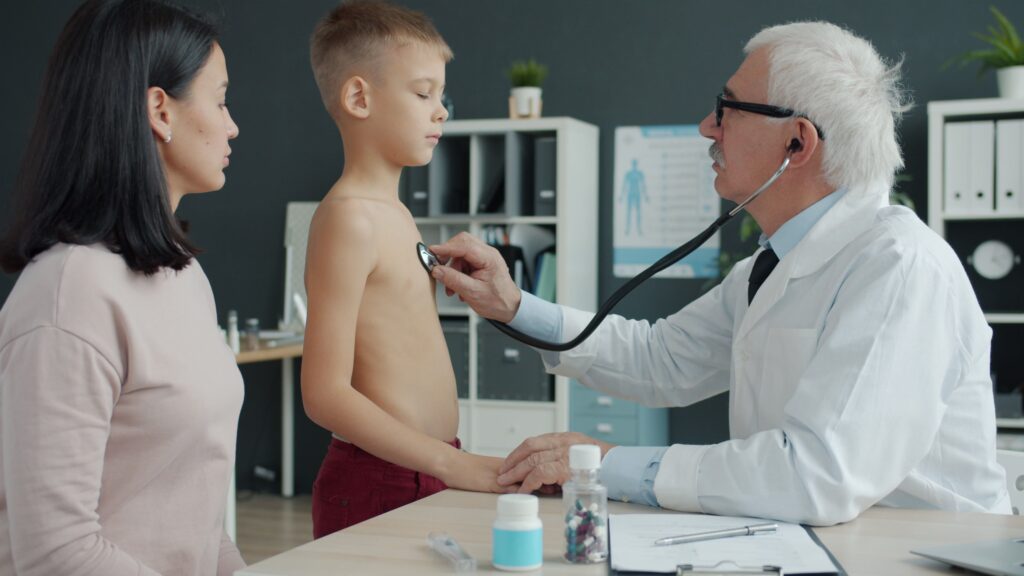 doctor checking boy's heart beat