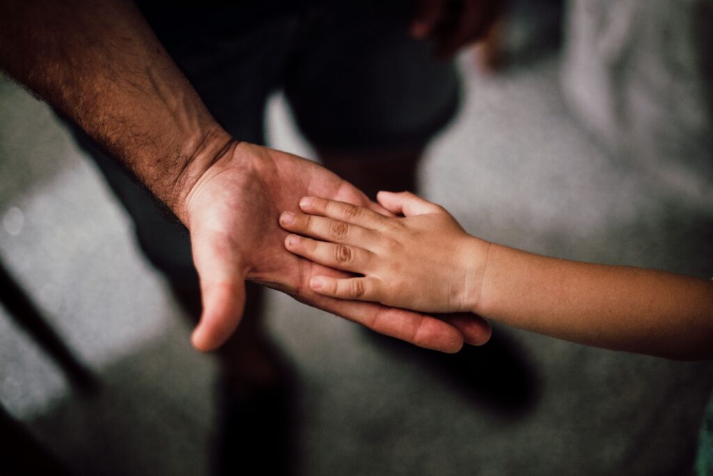 father and son touching hands