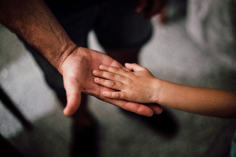 father and son touching hands